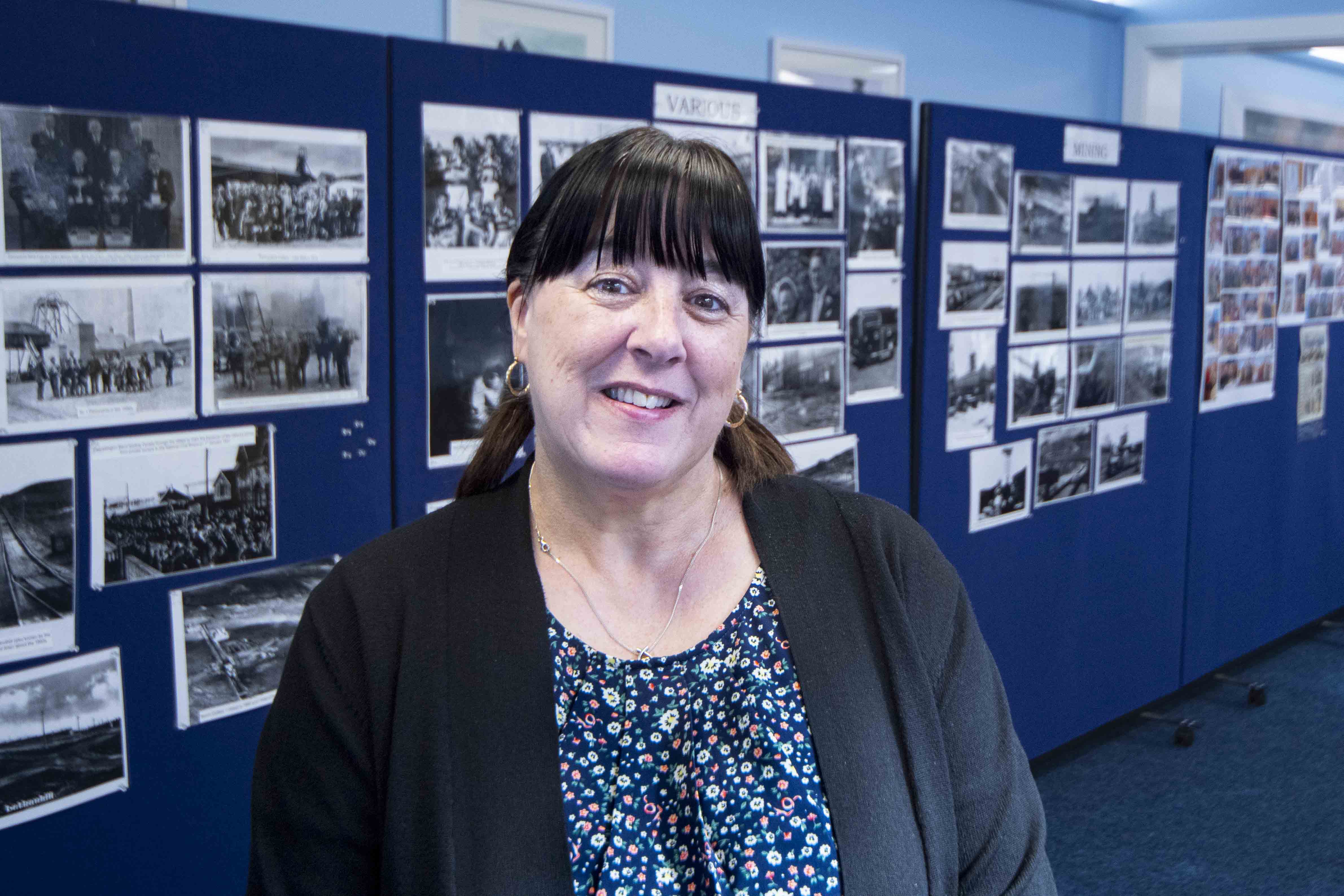 Sharon Smith in Dalmellington Community Centre function room with a display of archive photographs of the local mining community.